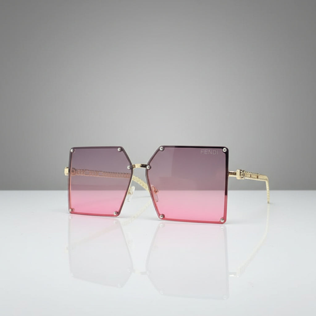 Square aviator-style sunglasses with a gold metal frame and pink-to-clear gradient lenses, displayed on a reflective white surface against a white background.