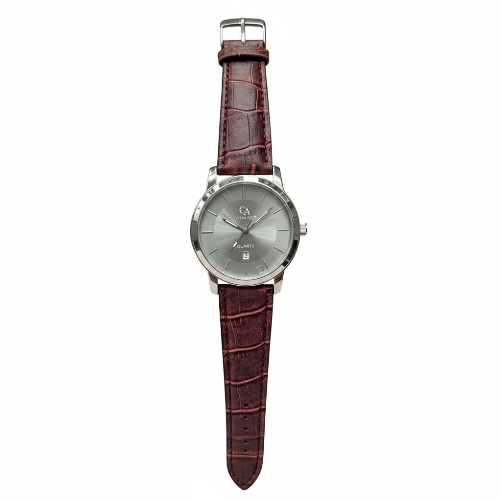 A wristwatch with a silver dial and a dark reddish-brown crocodile-embossed leather strap, held in a person's hand against a gray textured background.